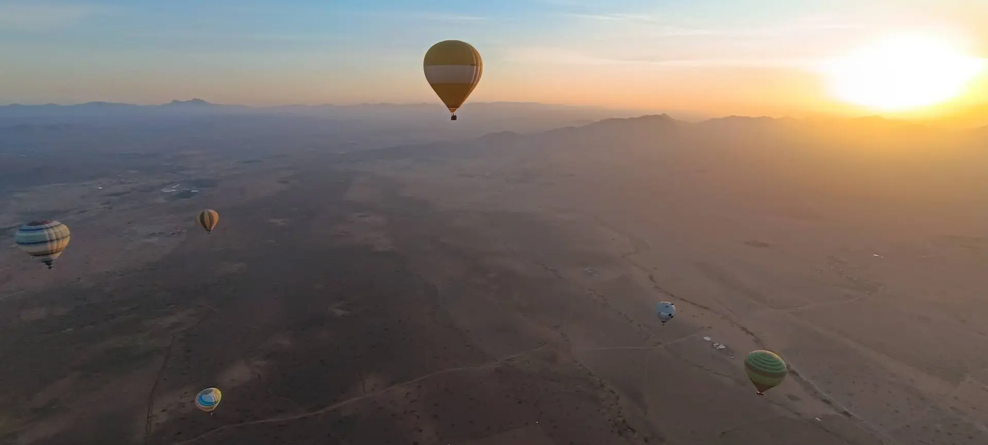 Montgolfières au-dessus de la Palmeraie de Marrakech au lever du soleil